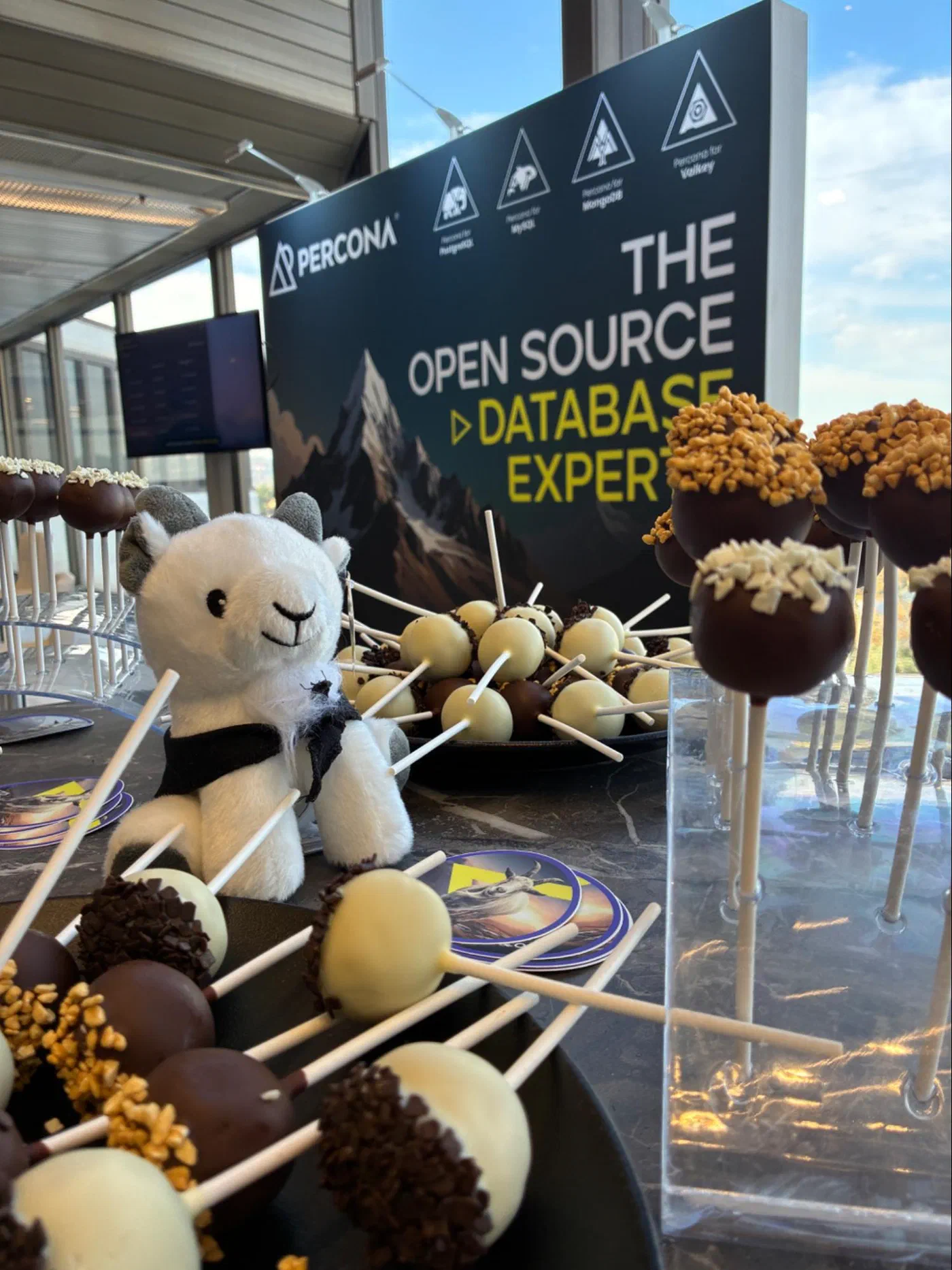 Cake pops and Percona goat mascot on the booth table at Open Source Summit Europe